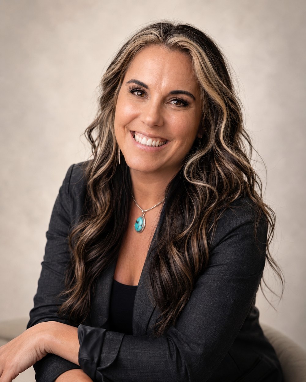 Ashley Sara, Search Experience Strategist, smiling in a dark blazer with a turquoise pendant